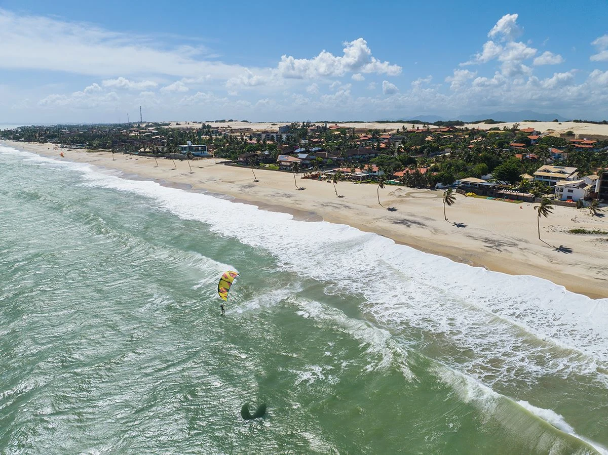 Fotografia real da praia de Cumbuco com um kitesurfista