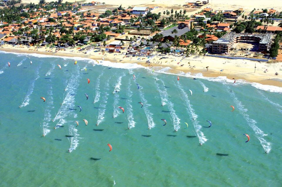 Velas coloridas de kitesurf na praia de Cumbuco